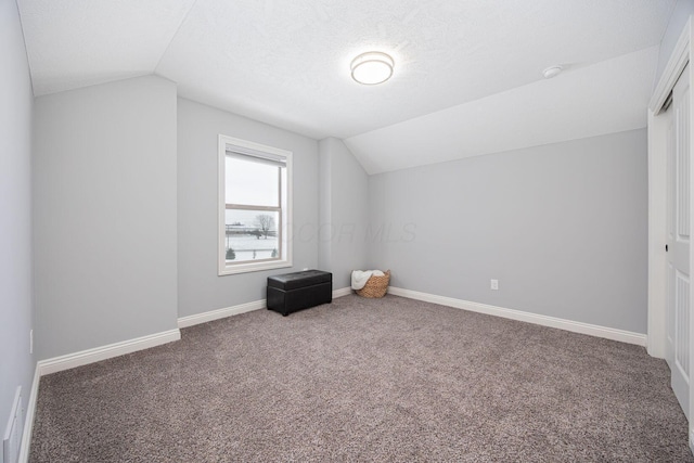 bonus room featuring a textured ceiling, lofted ceiling, and carpet floors