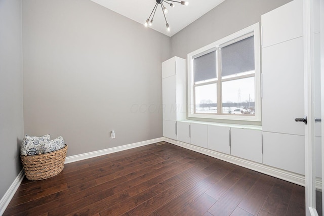 unfurnished room with hardwood / wood-style flooring and a notable chandelier