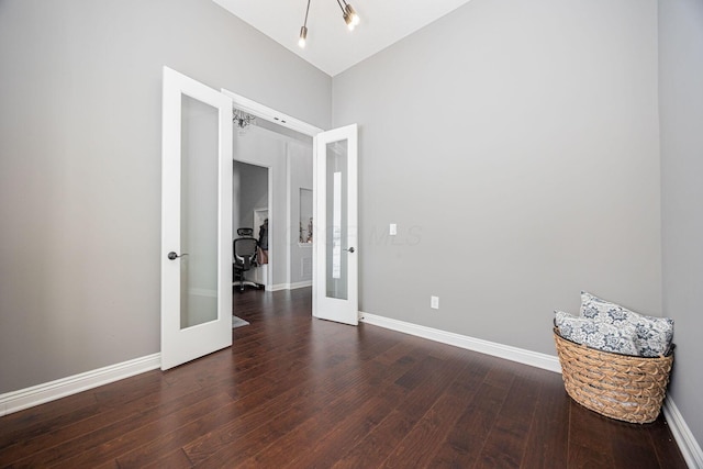 unfurnished room featuring french doors and dark wood-type flooring