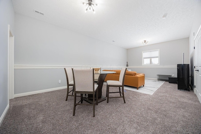 dining space featuring carpet floors and a textured ceiling