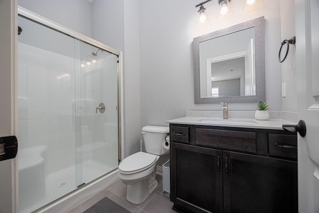 bathroom featuring tile patterned floors, vanity, toilet, and an enclosed shower