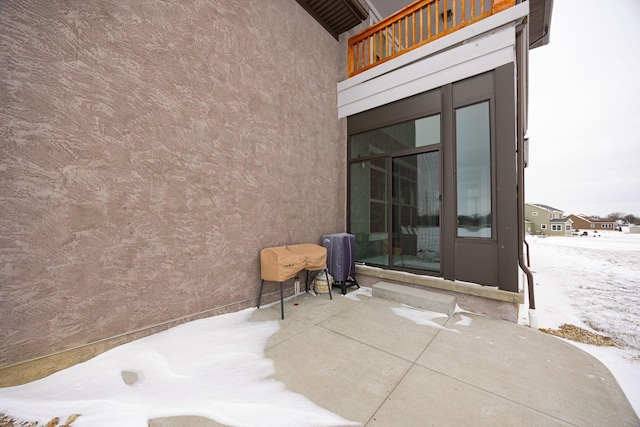 snow covered patio with a balcony