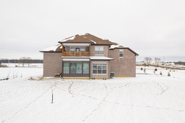 snow covered property with a balcony