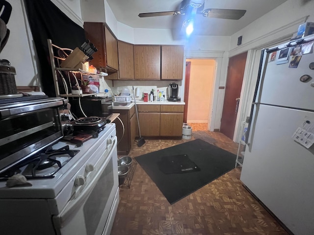 kitchen with ceiling fan, a center island, and white appliances