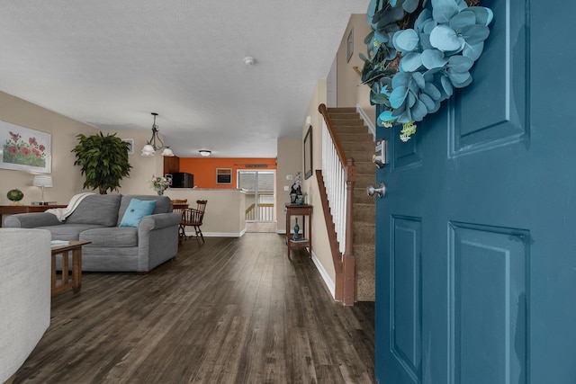 entryway featuring a textured ceiling, dark hardwood / wood-style floors, and an inviting chandelier