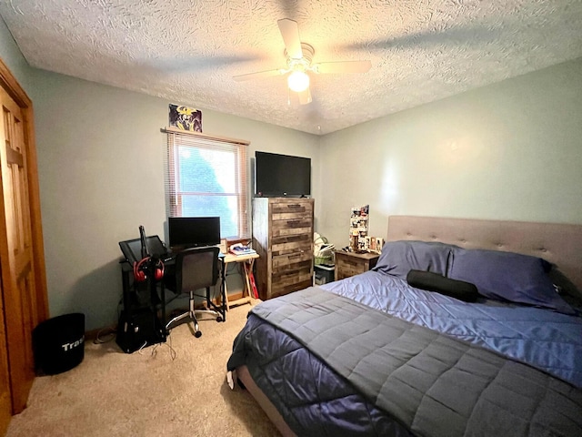 carpeted bedroom featuring ceiling fan and a textured ceiling