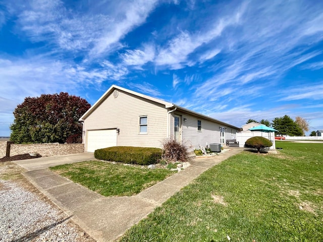 view of home's exterior with a yard, a garage, and cooling unit