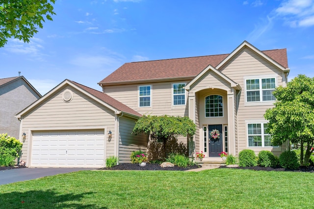 view of property with a garage and a front lawn