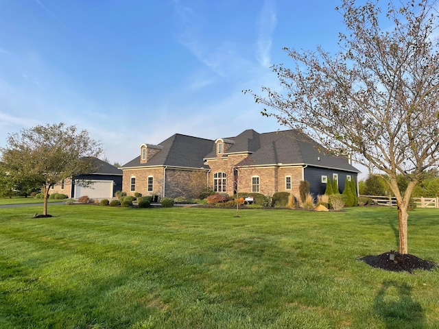 french provincial home with a front lawn and a garage