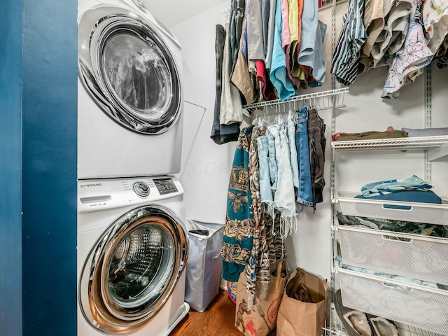 clothes washing area with wood-type flooring and stacked washer and clothes dryer