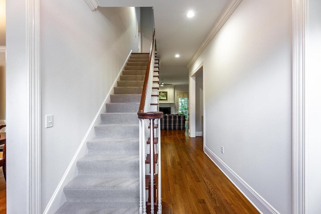 stairway featuring hardwood / wood-style floors and ornamental molding