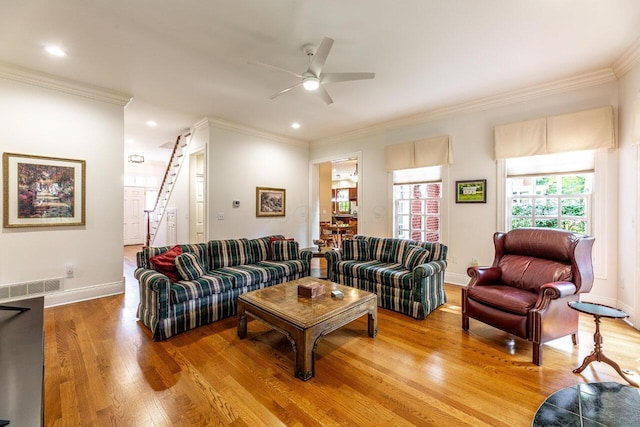 living room with light hardwood / wood-style flooring, ceiling fan, and ornamental molding