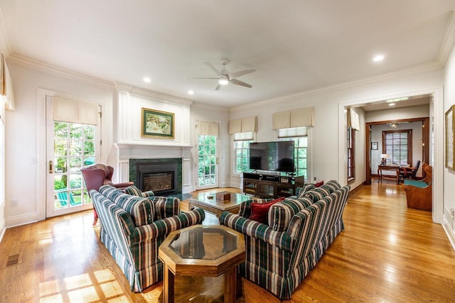 living room with ceiling fan, light hardwood / wood-style floors, and ornamental molding