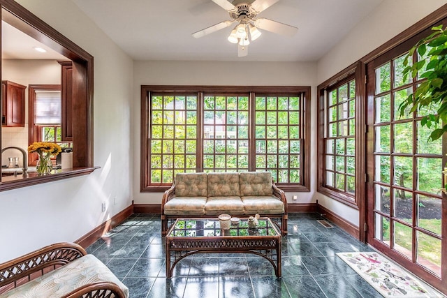 sunroom / solarium featuring ceiling fan and sink