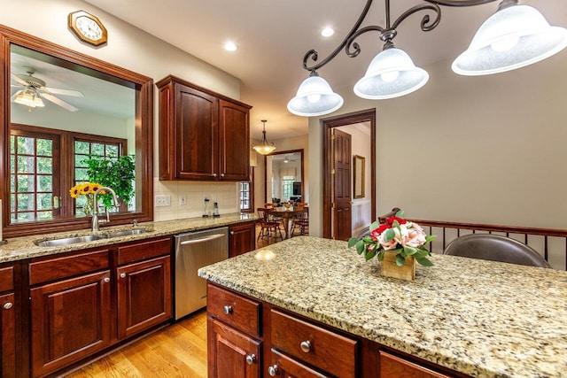 kitchen featuring ceiling fan, dishwasher, sink, hanging light fixtures, and tasteful backsplash