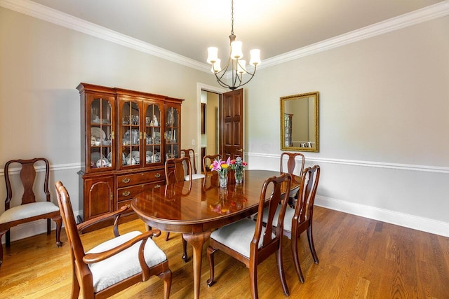 dining area featuring a chandelier, hardwood / wood-style flooring, and crown molding