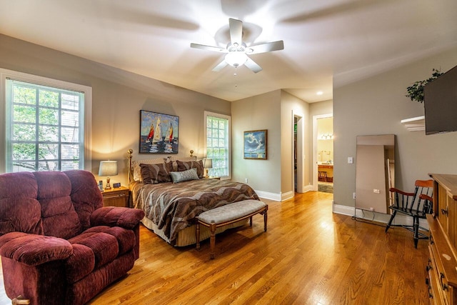 bedroom featuring ensuite bathroom, light hardwood / wood-style flooring, and ceiling fan