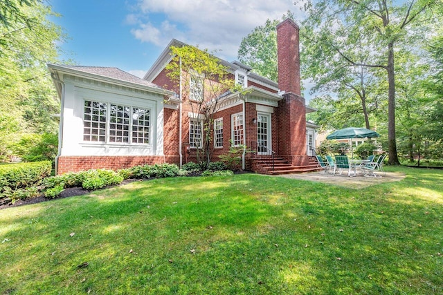 rear view of house with a lawn and a patio area