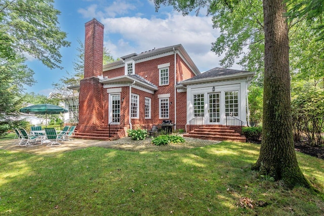 rear view of property with a yard and a patio area