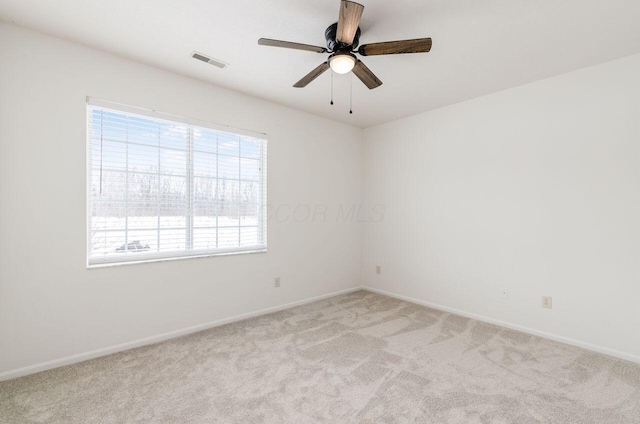 empty room with ceiling fan and light carpet