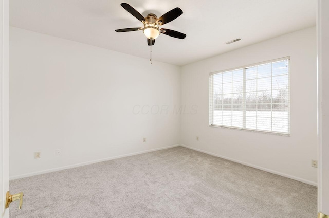 spare room featuring light colored carpet and ceiling fan