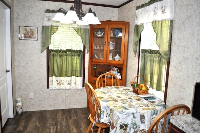 dining space featuring dark hardwood / wood-style floors, ornamental molding, and an inviting chandelier