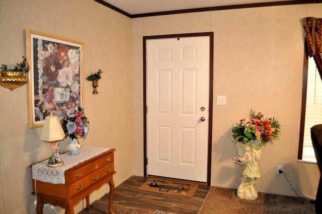 foyer entrance with dark hardwood / wood-style flooring and ornamental molding