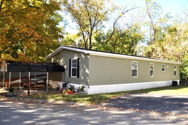 view of side of property with a carport and central AC