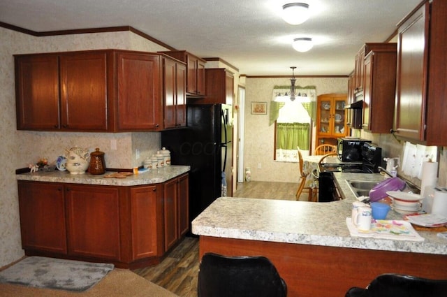 kitchen featuring pendant lighting, crown molding, kitchen peninsula, and dark wood-type flooring