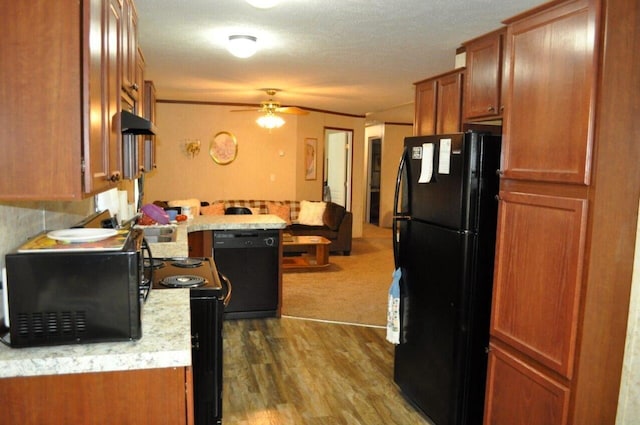 kitchen with black appliances, kitchen peninsula, ceiling fan, a textured ceiling, and wood-type flooring