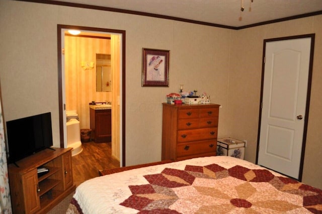 bedroom featuring connected bathroom, crown molding, and dark wood-type flooring