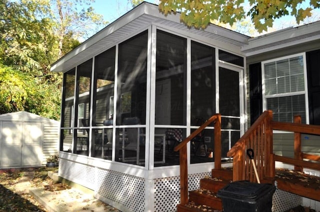 view of home's exterior featuring a sunroom and a shed