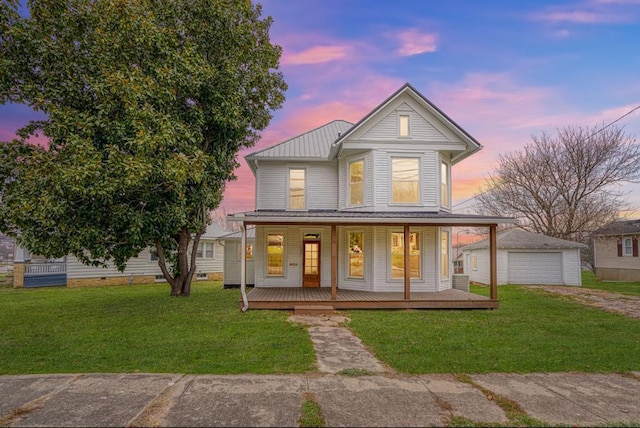 view of front of property with an outdoor structure, a porch, a garage, and a yard