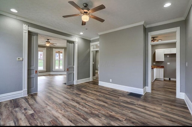 interior space featuring a textured ceiling, dark hardwood / wood-style flooring, and ornamental molding