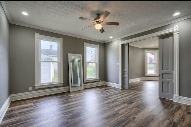 spare room featuring dark hardwood / wood-style floors, ornamental molding, and a textured ceiling