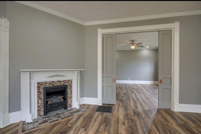 unfurnished living room with dark wood-type flooring, ceiling fan, crown molding, and a tiled fireplace