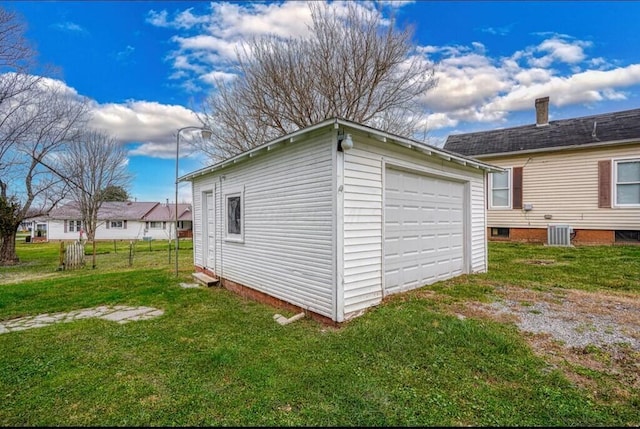 view of side of home featuring a yard, a garage, an outdoor structure, and central air condition unit