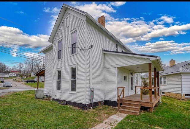 back of house featuring a yard, covered porch, and central AC unit