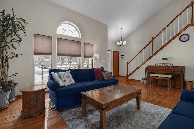 living room featuring high vaulted ceiling, dark wood-type flooring, and an inviting chandelier