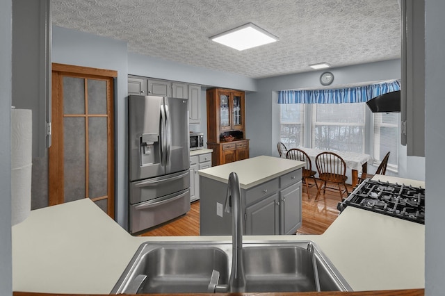 kitchen featuring a textured ceiling, gray cabinets, sink, and appliances with stainless steel finishes