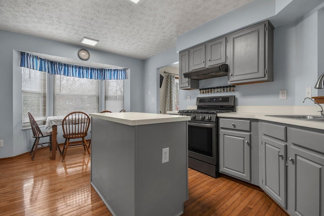 kitchen featuring light hardwood / wood-style floors, stainless steel gas range, a textured ceiling, sink, and gray cabinets