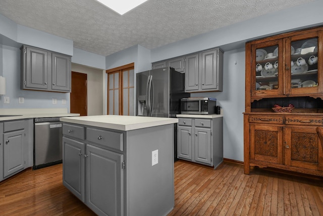 kitchen with appliances with stainless steel finishes, a center island, and gray cabinets