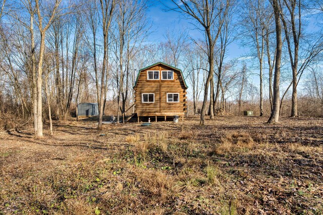 rear view of property featuring an outbuilding