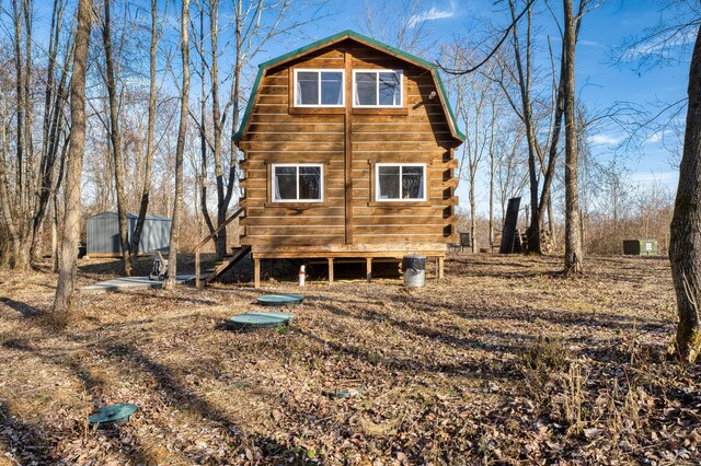 rear view of property featuring an outbuilding