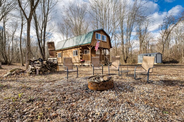 view of yard featuring an outdoor fire pit and a storage shed