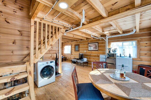 dining area with wooden walls, light hardwood / wood-style flooring, beam ceiling, washer / dryer, and wood ceiling