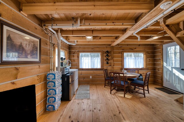 dining space with wood walls, beam ceiling, and wooden ceiling