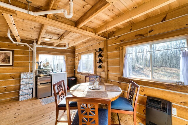 dining area with beam ceiling, heating unit, wooden ceiling, and light hardwood / wood-style floors