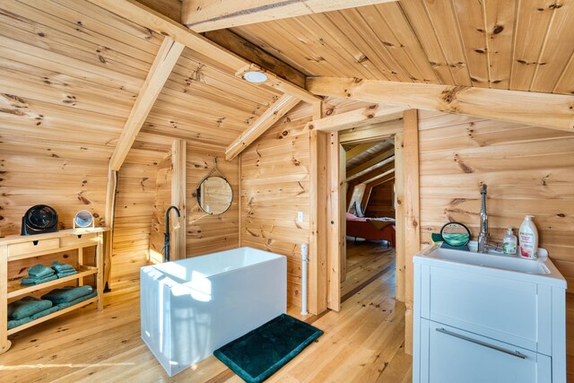 bonus room with light wood-type flooring, vaulted ceiling with beams, sink, and wood ceiling