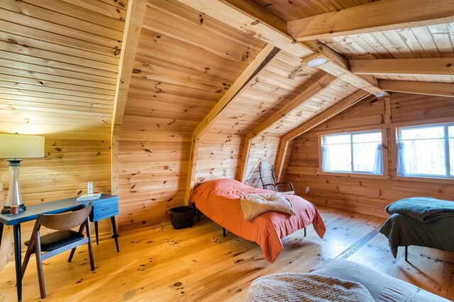 bedroom with lofted ceiling with beams, light hardwood / wood-style flooring, wood walls, and wood ceiling